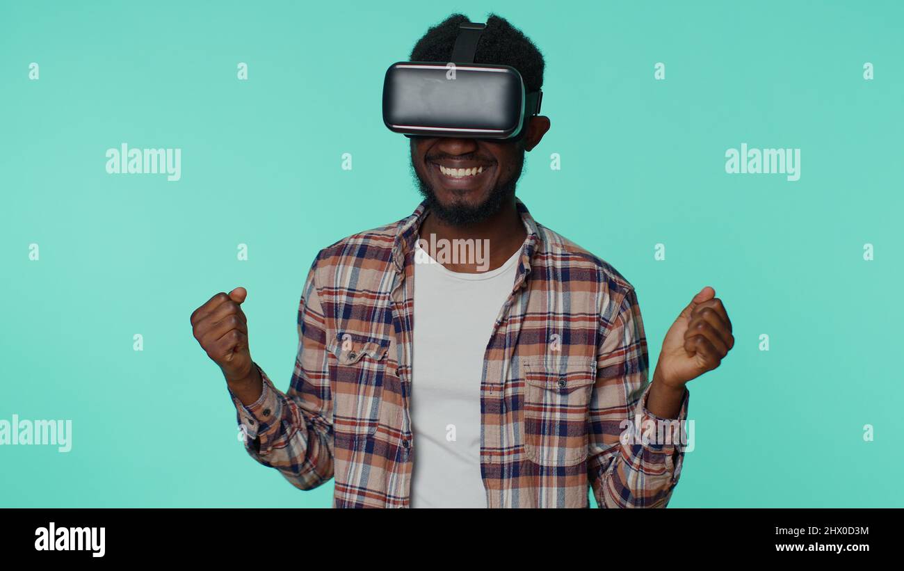 Man using virtual reality futuristic technology VR headset helmet to play simulation 3D video game Stock Photo