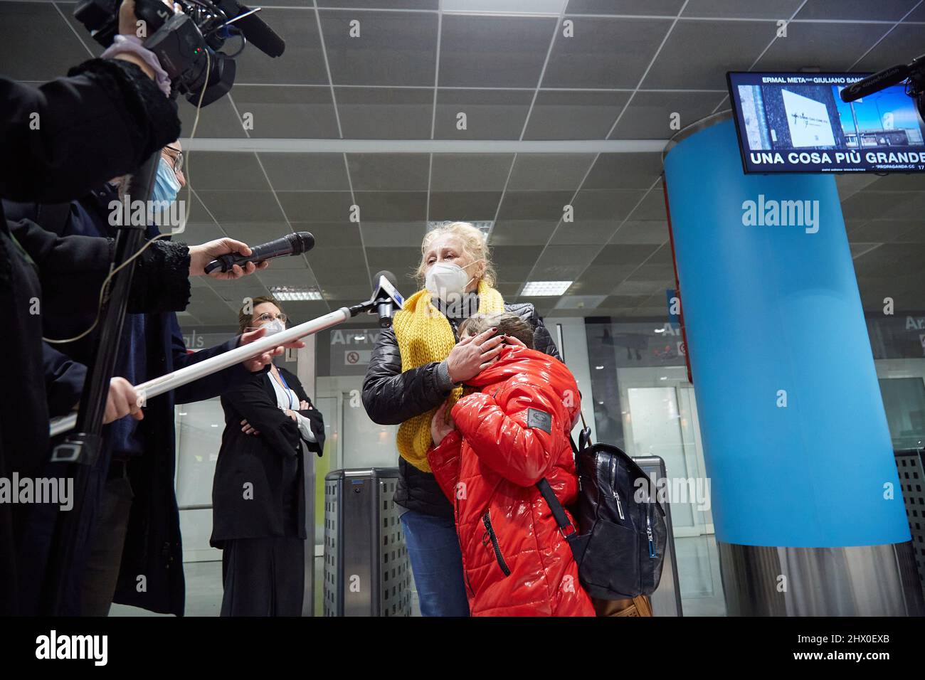 Palermo, Sicily, Italy. 8th Mar, 2022. Arrival of the first Ukrainian refugees in Palermo.The flight, from Krakow, Poland, landed around 5:00 p.m. at the Falcone Borsellino airport in Punta Raisi, Palermo.Upon arrival, refugees, welcomed by relatives and UNHCR volunteers, have carried out the anti-COVID protocol before leaving the airport. Citizen of Ukrainian origin attends crying to the press with her granddaughter. (Credit Image: © Victoria Herranz/ZUMA Press Wire) Stock Photo