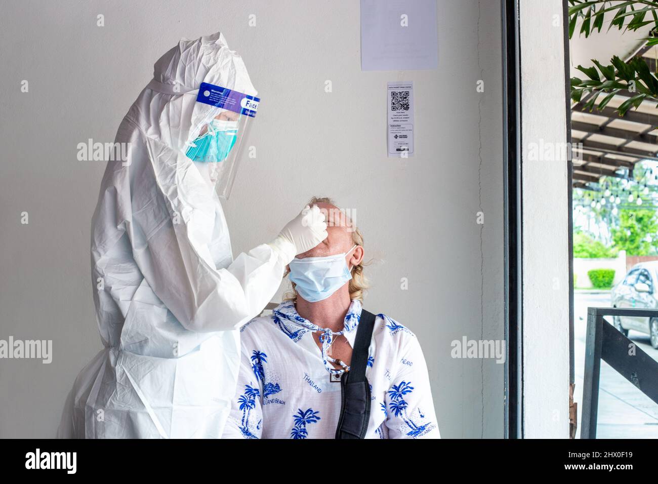 A health worker takes a swab from the nose for covid-19 PCR to a tourist who has flown abroad on vacation. Rules for visiting countries. Thailand, Phu Stock Photo