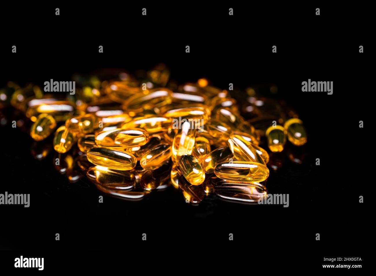 Macro Close up of Omega 3 gel capsule on a reflective black background
