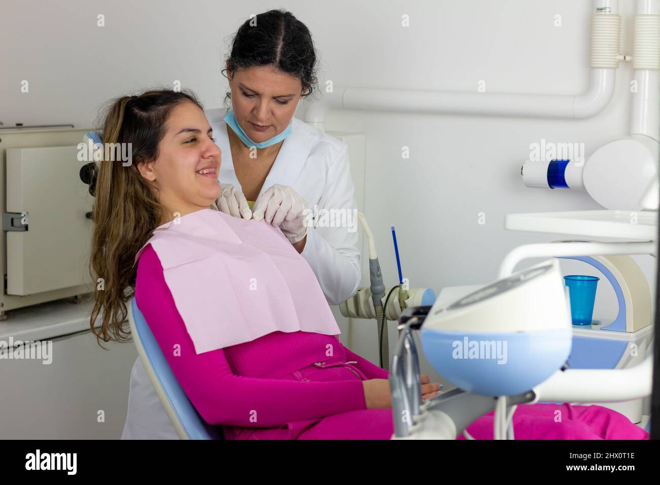 Dentist doctor puts dental napkin on patient. Preparing the patient for a dental examination