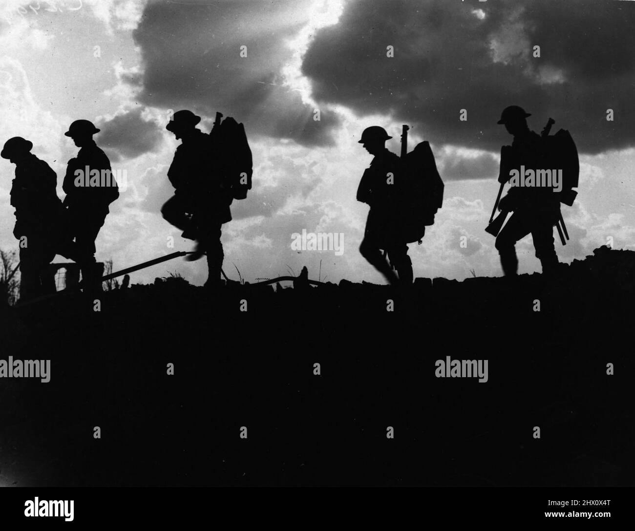 Soldiers in silhouette against the sunset as they move up to the front during the Battle of the Somme in WW1 Stock Photo