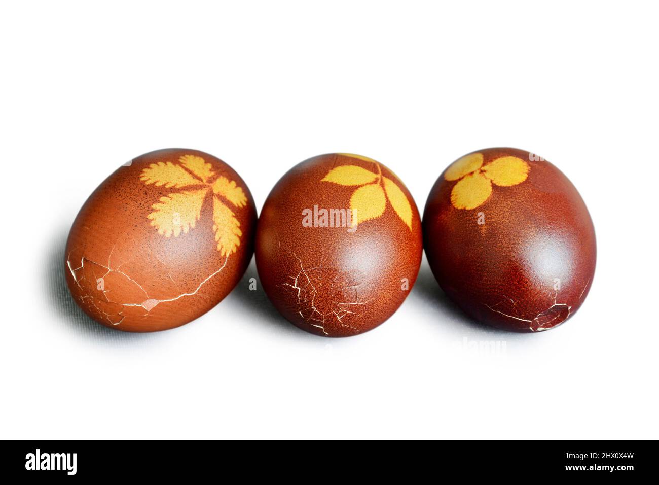 Cracked Easter eggs dyed with onion skins isolated on white background Stock Photo