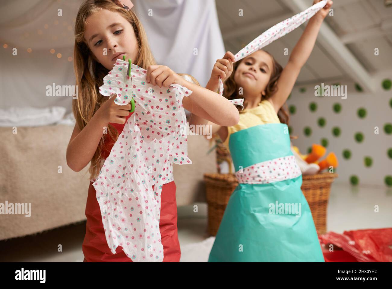 Sisters make the best friends. Shot of two little girls having fun making dresses. Stock Photo