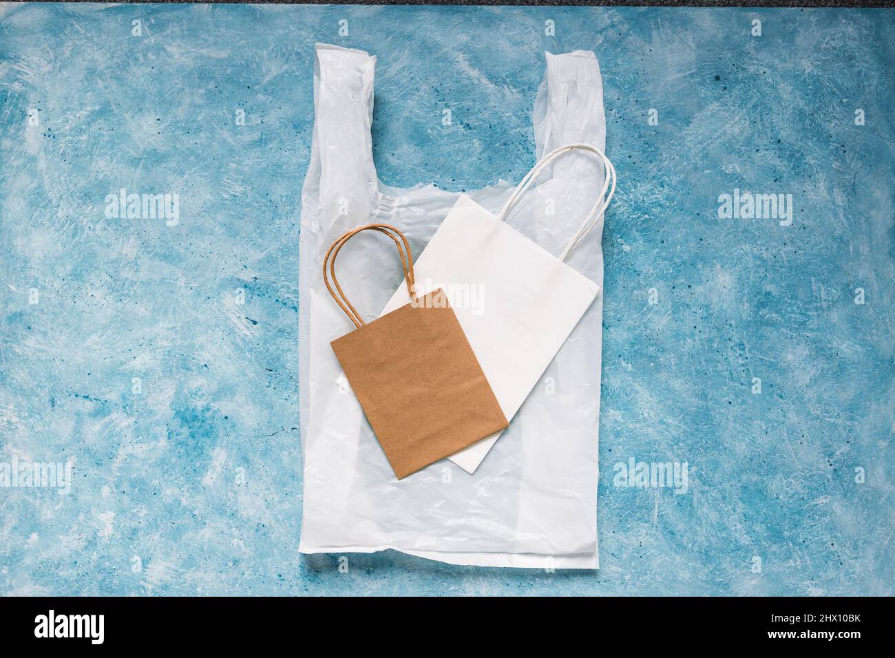 single use plastic bag next to paper ones, plastic pollution and