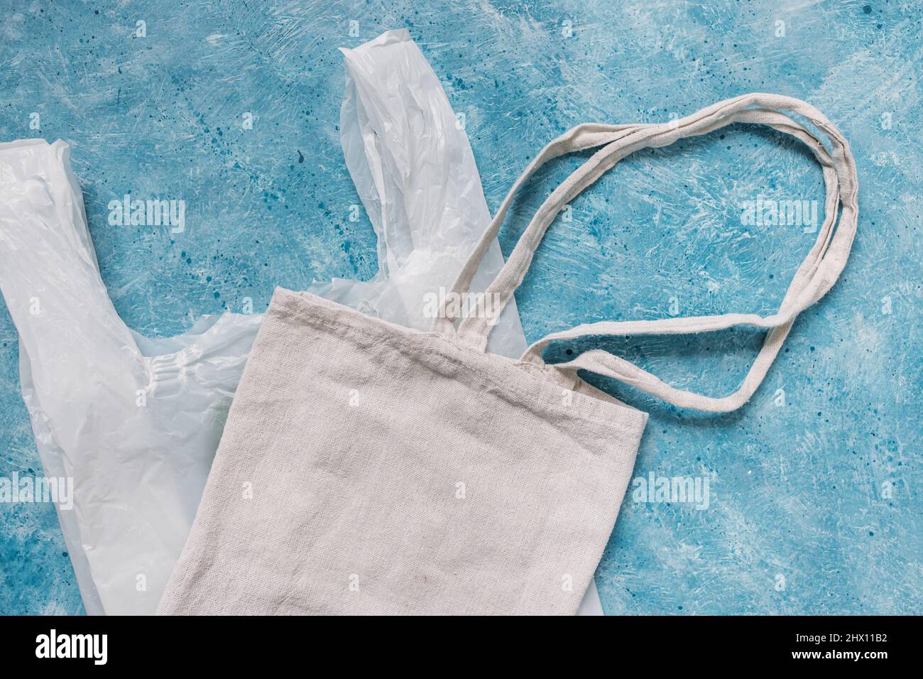 single use plastic bag next to reusable canvas one, plastic pollution