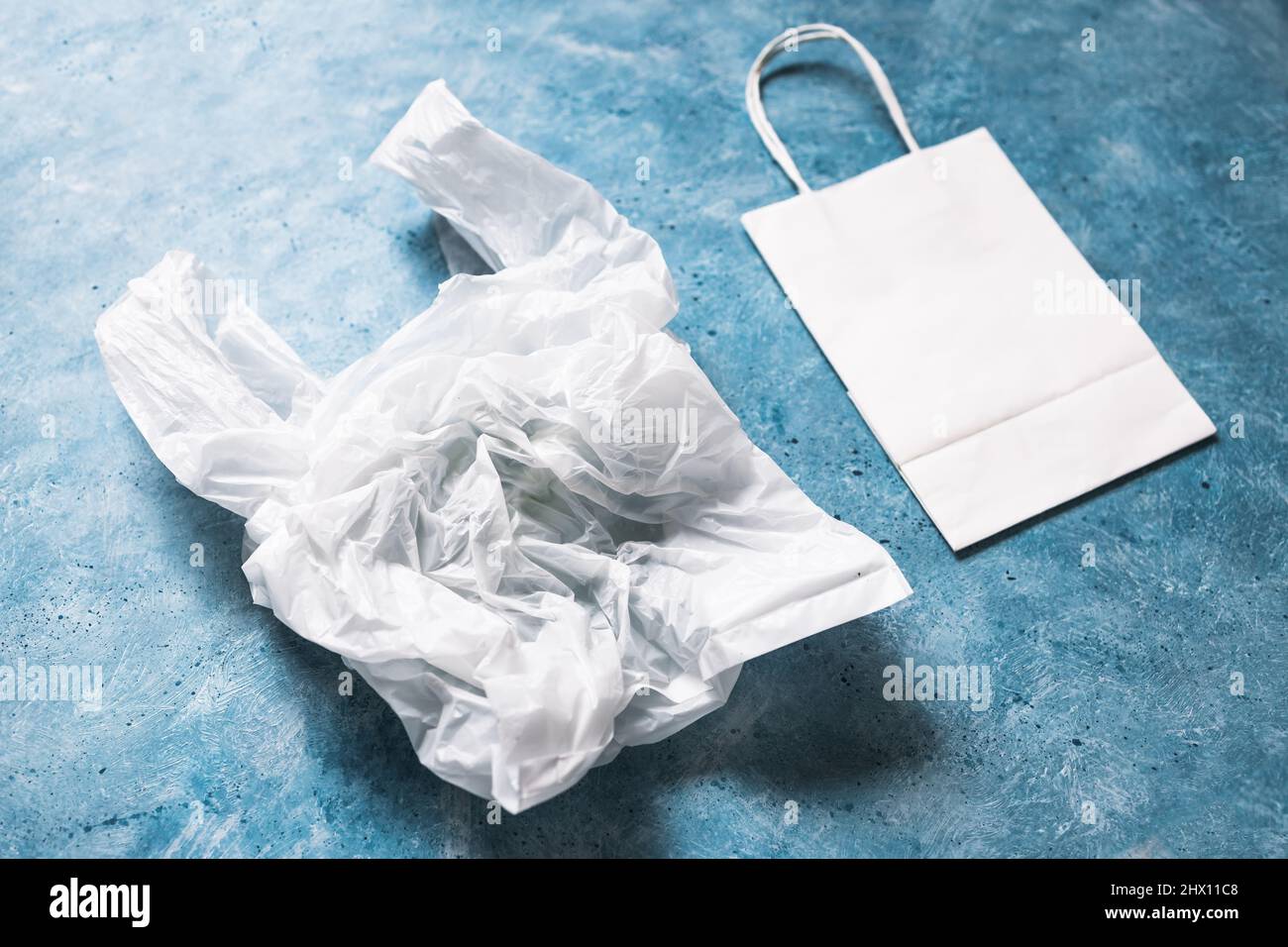 single use plastic bag next to paper one, plastic pollution and