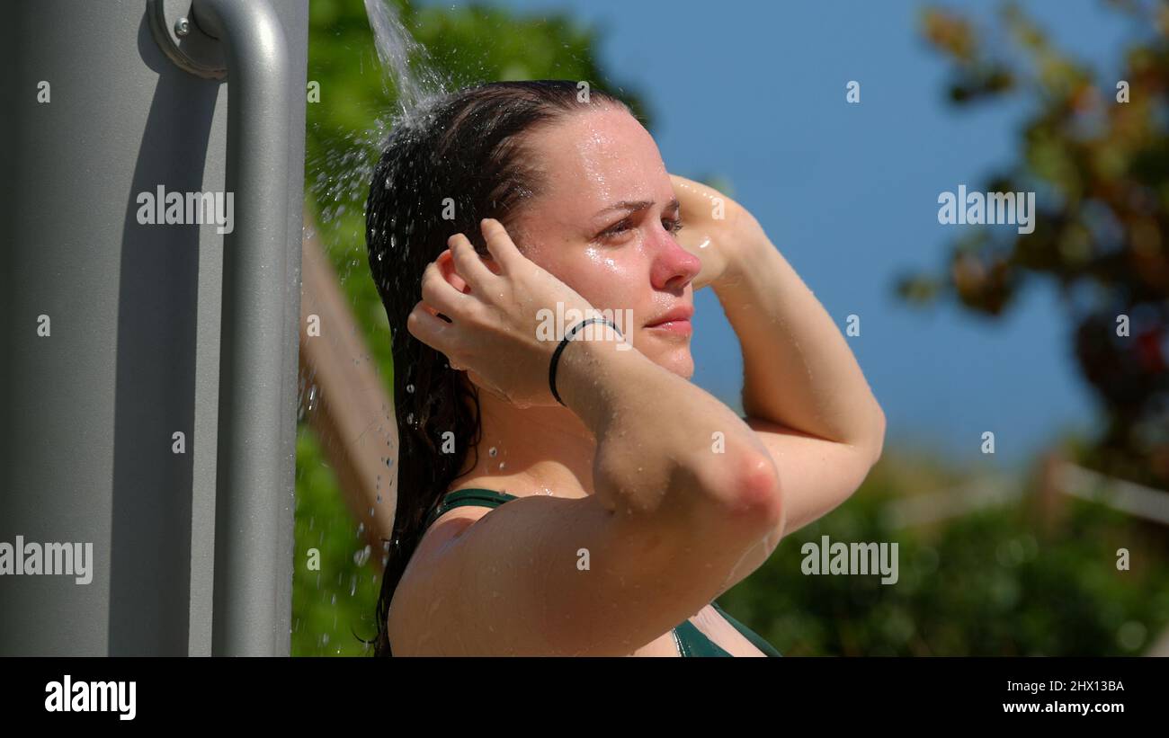 Young woman taking a shower after sun bathing at the beach Stock Photo