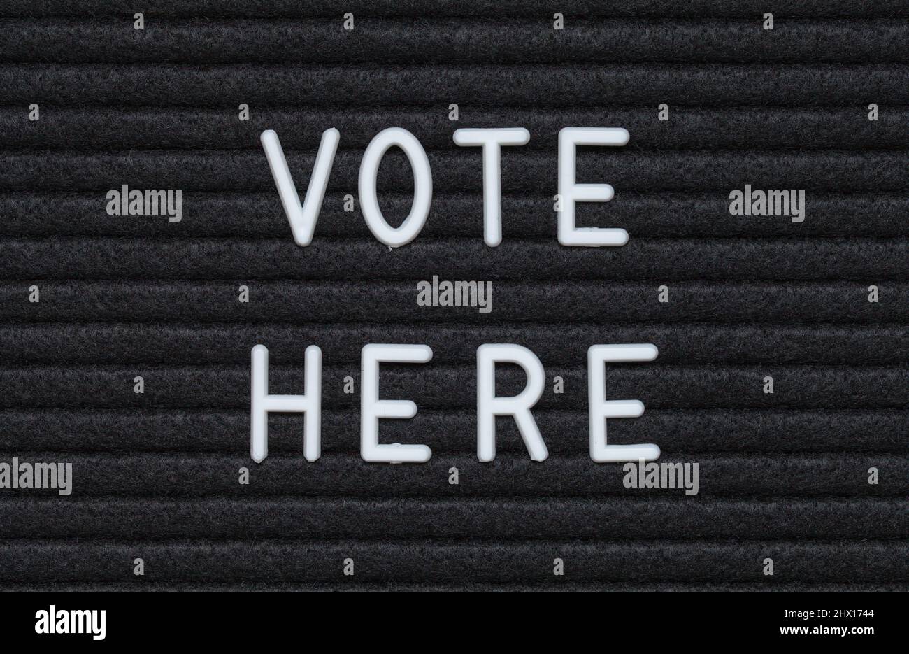 Vote Here Black Felt Letter Board Sign. Stock Photo