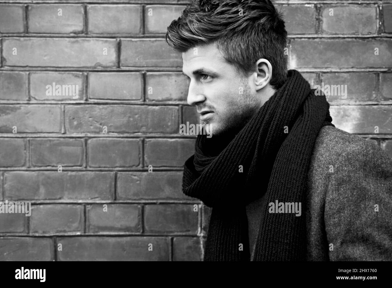 Bring style to Winter. Black and white shot of a stylishly-dressed young man standing in the street. Stock Photo