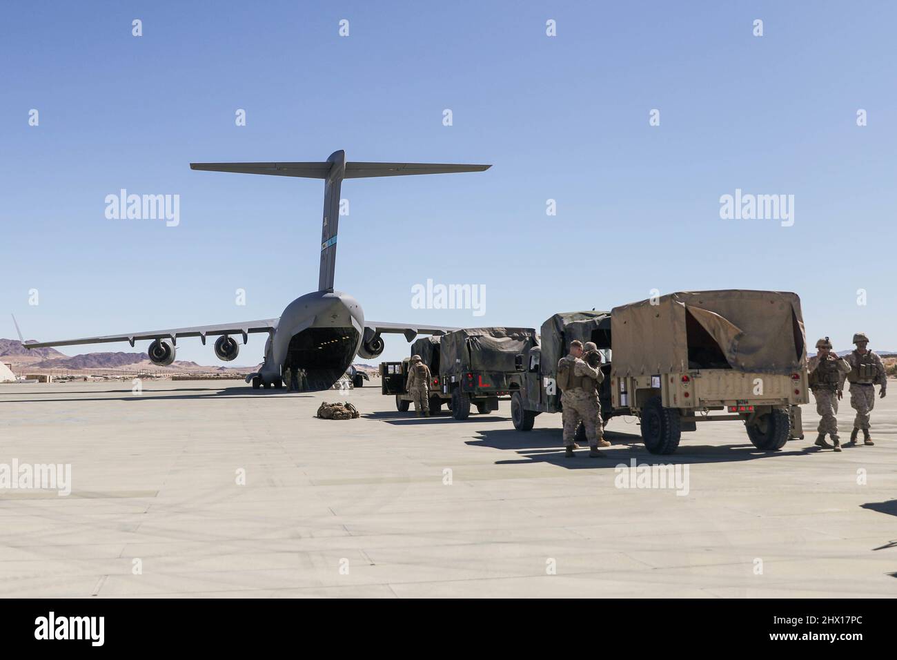 U.S. Marines with 7th Marine Regiment, 1st Marine Division, stage tactical vehicles in preparation to board a C-17 Globemaster III assigned to 3rd Airlift Squadron, Dover Air Force Base, Delaware, during a command post exercise (CPX) at Marine Corps Air Ground Combat Center Twentynine Palms, California, March 1, 2022. This evolution provided an opportunity for Marines to practice expedient setup of a regimental headquarters, enabling command and control from distributed locations. (U.S. Marine Corps photo by Sgt. Jailine L. AliceaSantiago) Stock Photo