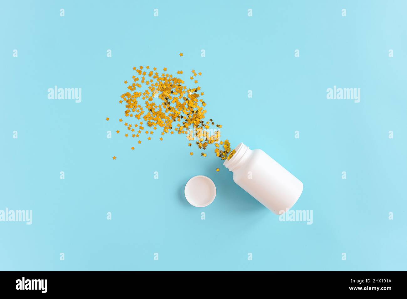 Gold stars confetti fly out white medical bottle on pink background. Concept sleeping pills, melatonin for insomnia, therapy with antidepressants for Stock Photo