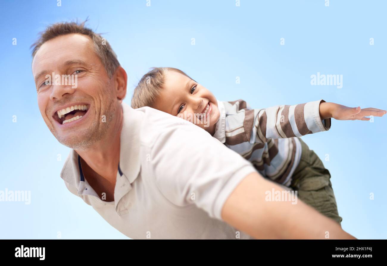 Special bonding time. Shot of a father piggybacking his young son. Stock Photo