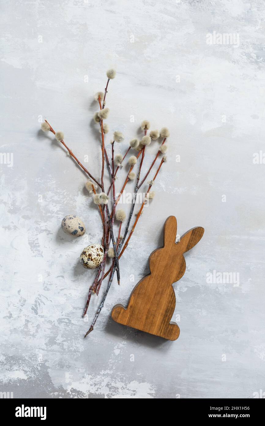 Happy Easter concept with rabbit, willow branches and quail eggs on a gray background. Easter background. Stock Photo