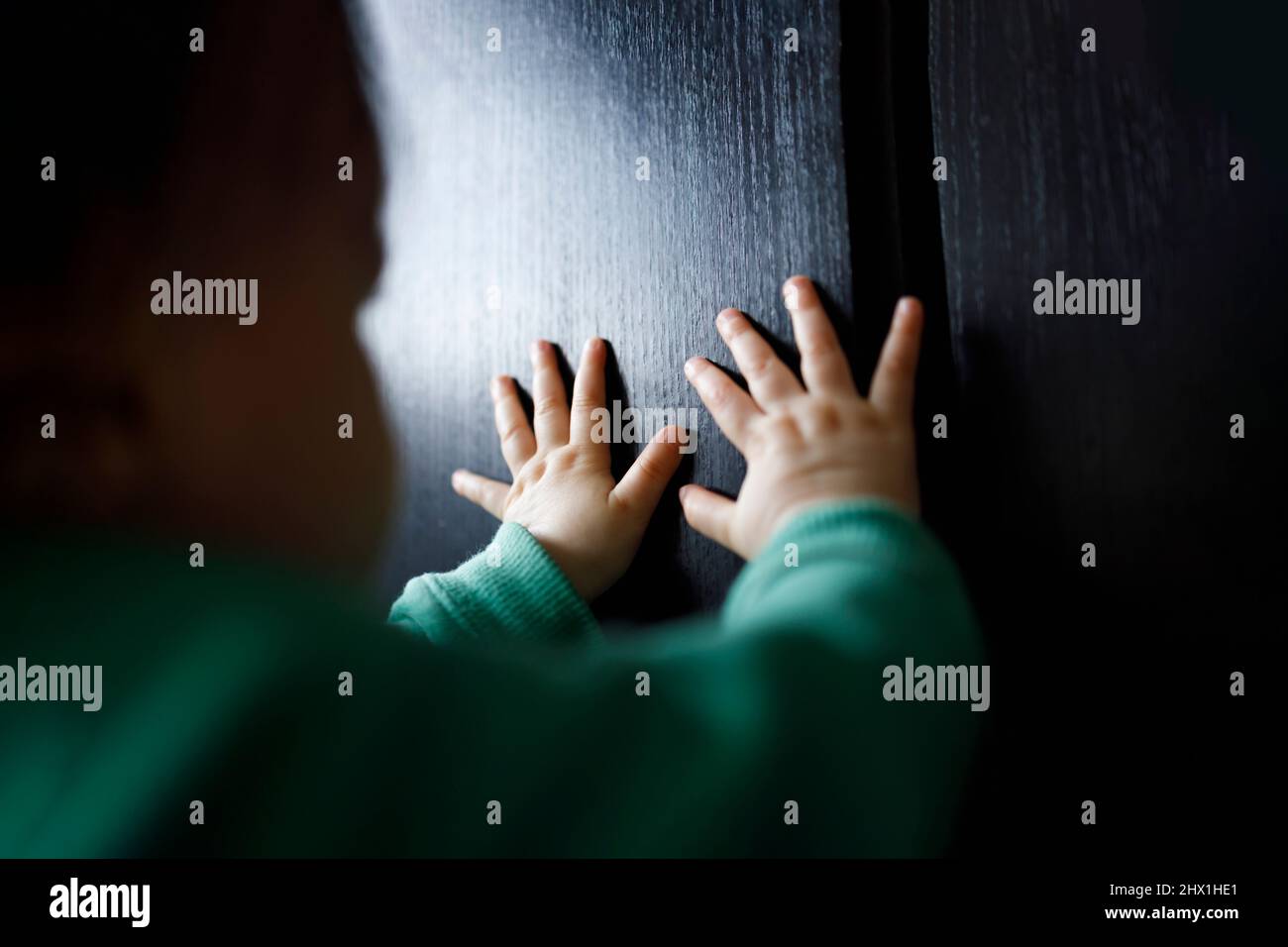Babies hand on a black surface, humanitarian aid concept Stock Photo