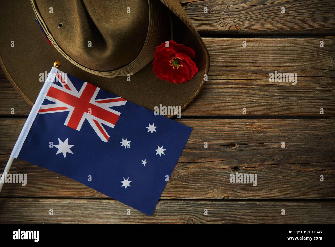 Anzac army slouch hat with Australian Flag and Poppy on wooden background Stock Photo