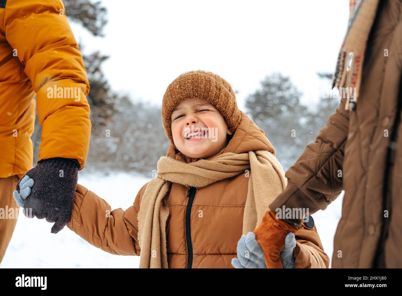 Happy family having a walk in winter outdoors in snow Stock Photo - Alamy