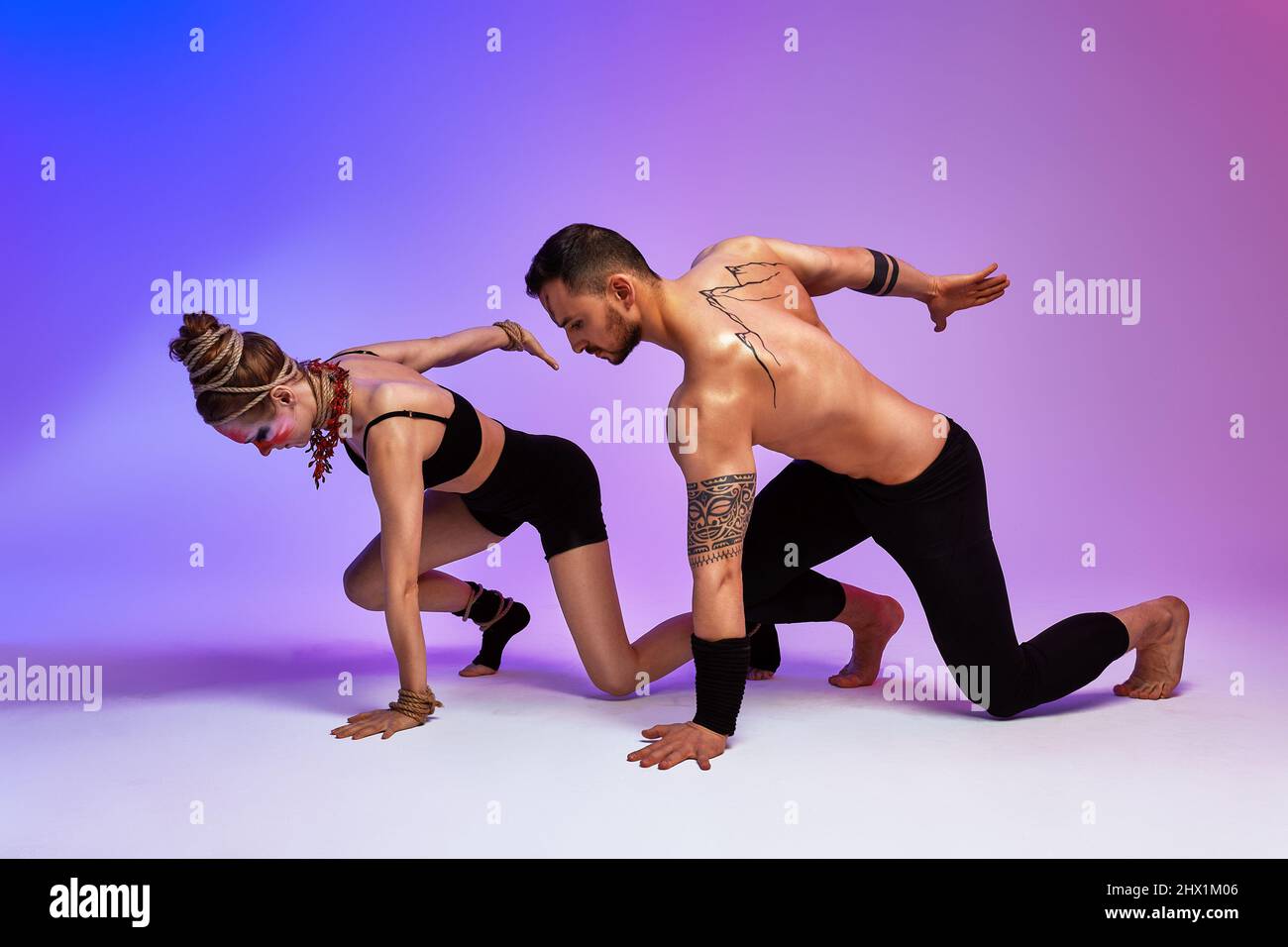 Beautiful young acrobats or gymnasts with colorful face painting on ...