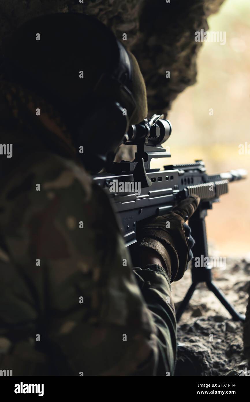 Machine automatic rifle precise aim from a rat hole in a destructed building . High quality photo Stock Photo