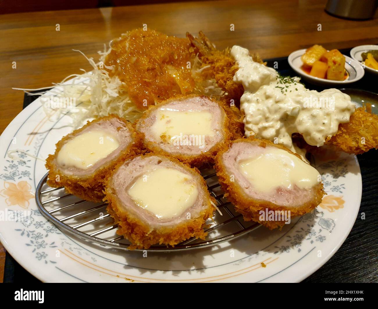 Cheese Katsu, a Japanese breaded, deepfried pork cutlet filled with cheese. Served with cabbage