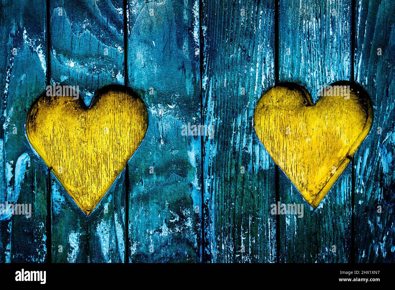 Architecture detail - two hearts Carved in old Wood in Ukrainian Flag Colors. Stock Photo