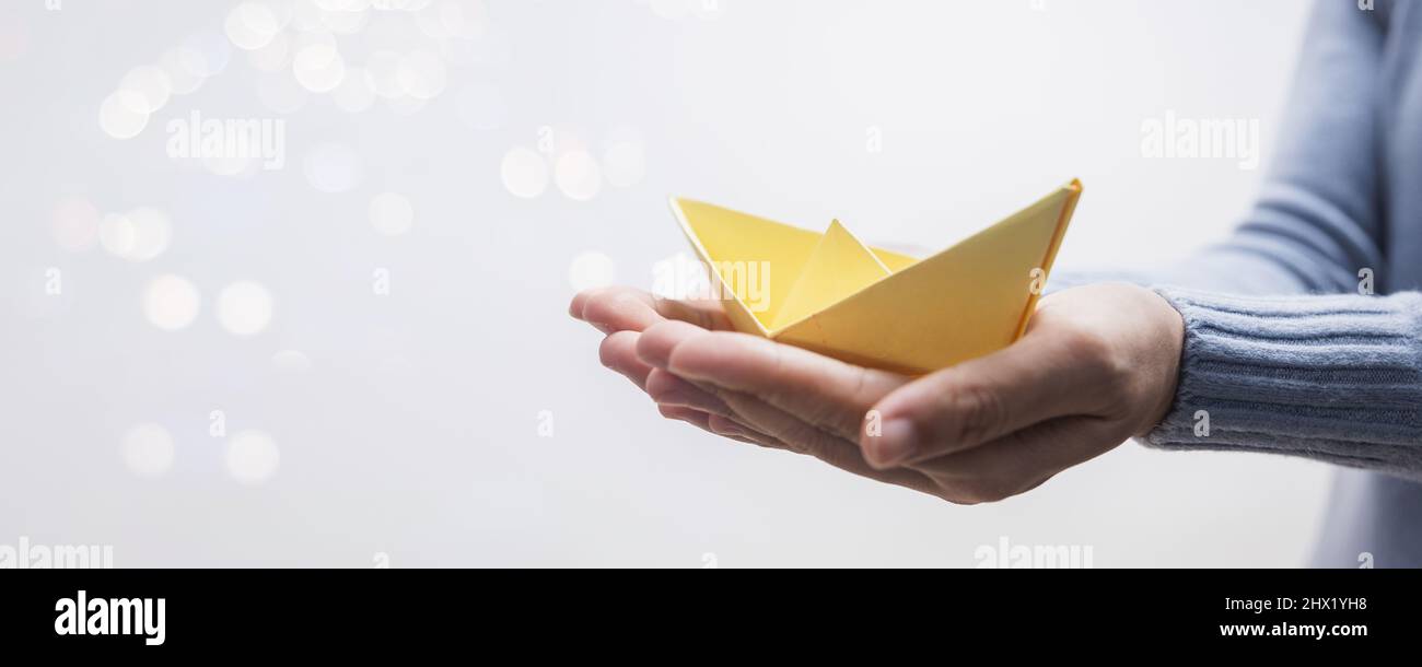 yellow paper boat on hand of woman leader Stock Photo