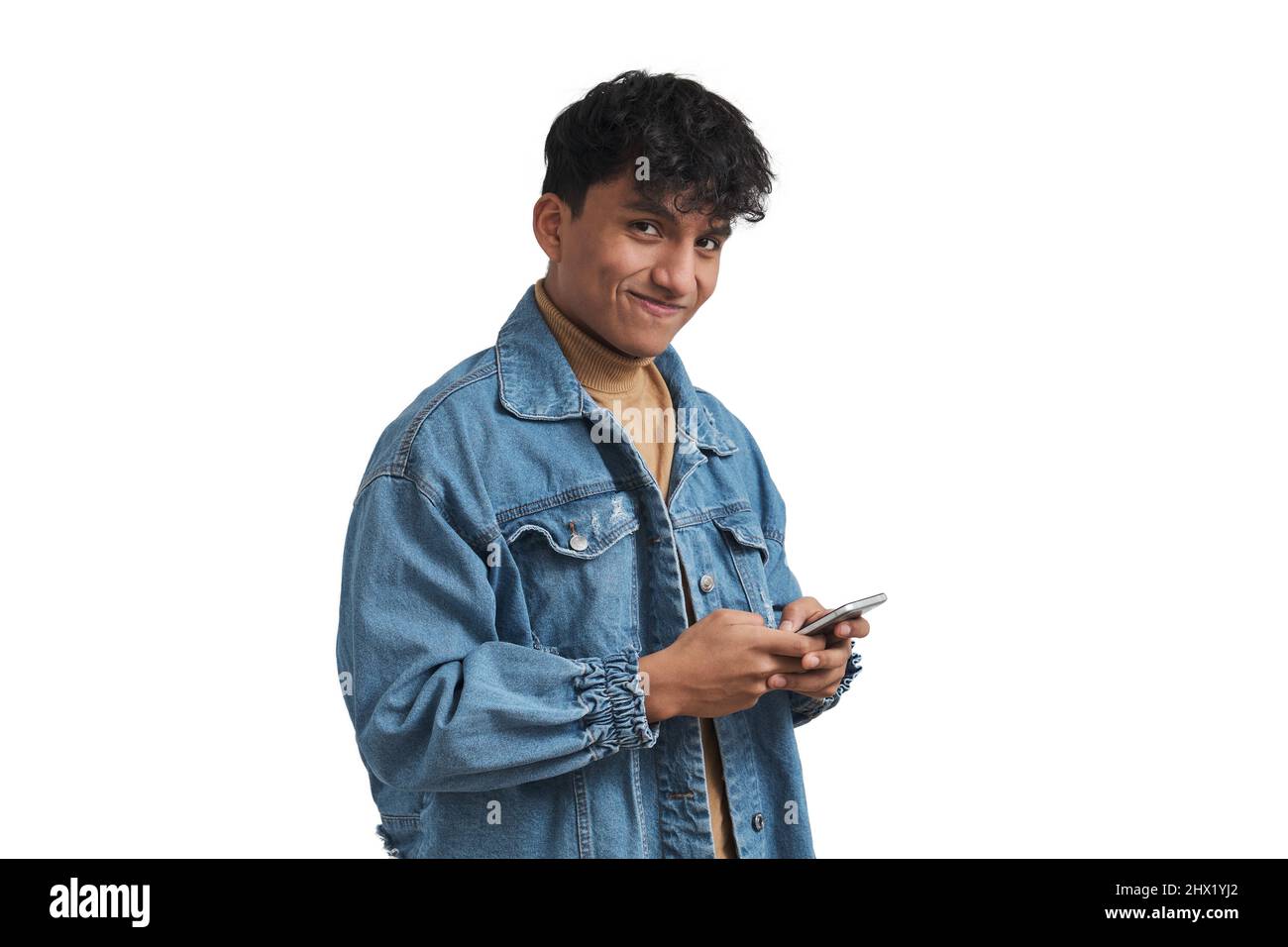 Young peruvian man using smartphone and looking at camera, isolated. Stock Photo