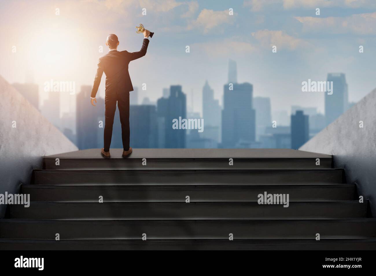 Successful businessman holding prize award trophy of success life and business, confidential achievement leader in suit get top of best goal step and Stock Photo