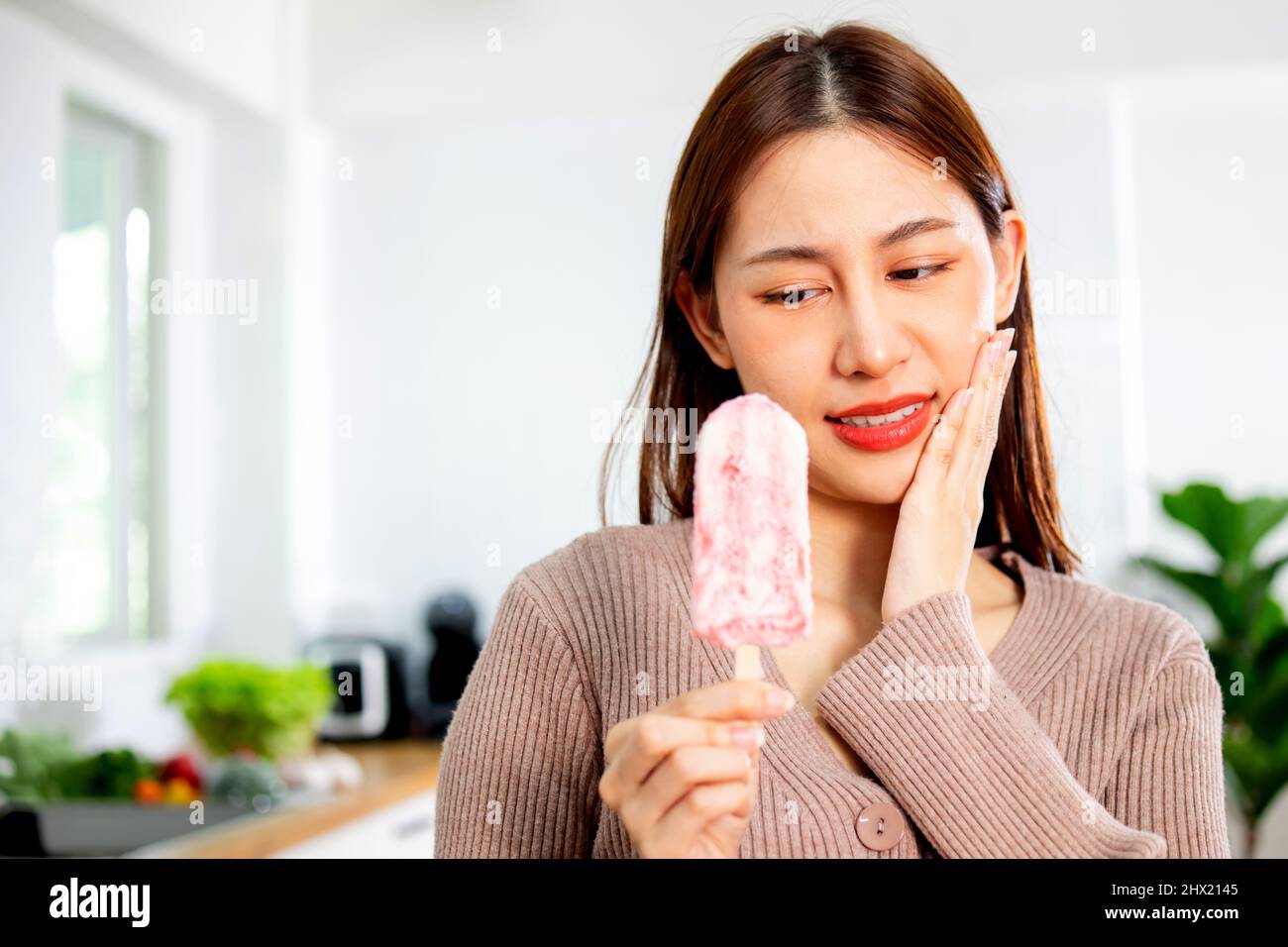 Asian woman has sensitive teeth during eating icecream Stock Photo Alamy