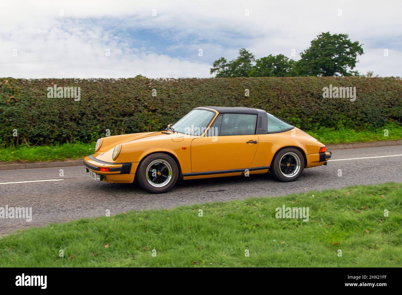 1978 70s seventies orange Porsche 911 2993cc 5 speed manual een-route to Capesthorne Hall classic August car show, Cheshire, UK Stock Photo