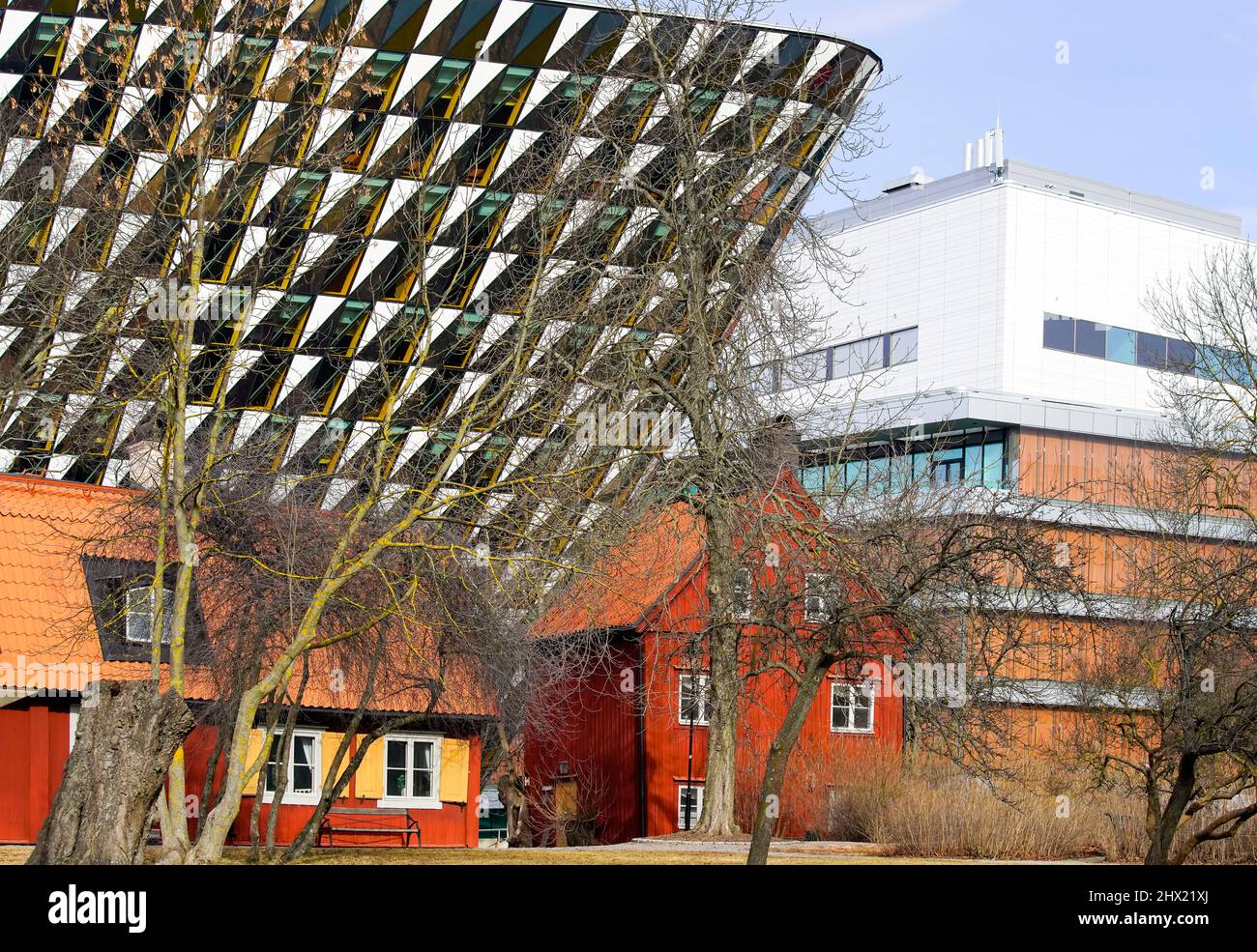 Traditional Swedish red timber house in  front of modern Aula Medica, Karolinska Institute in Solna, Stockholm Sweden. Stock Photo