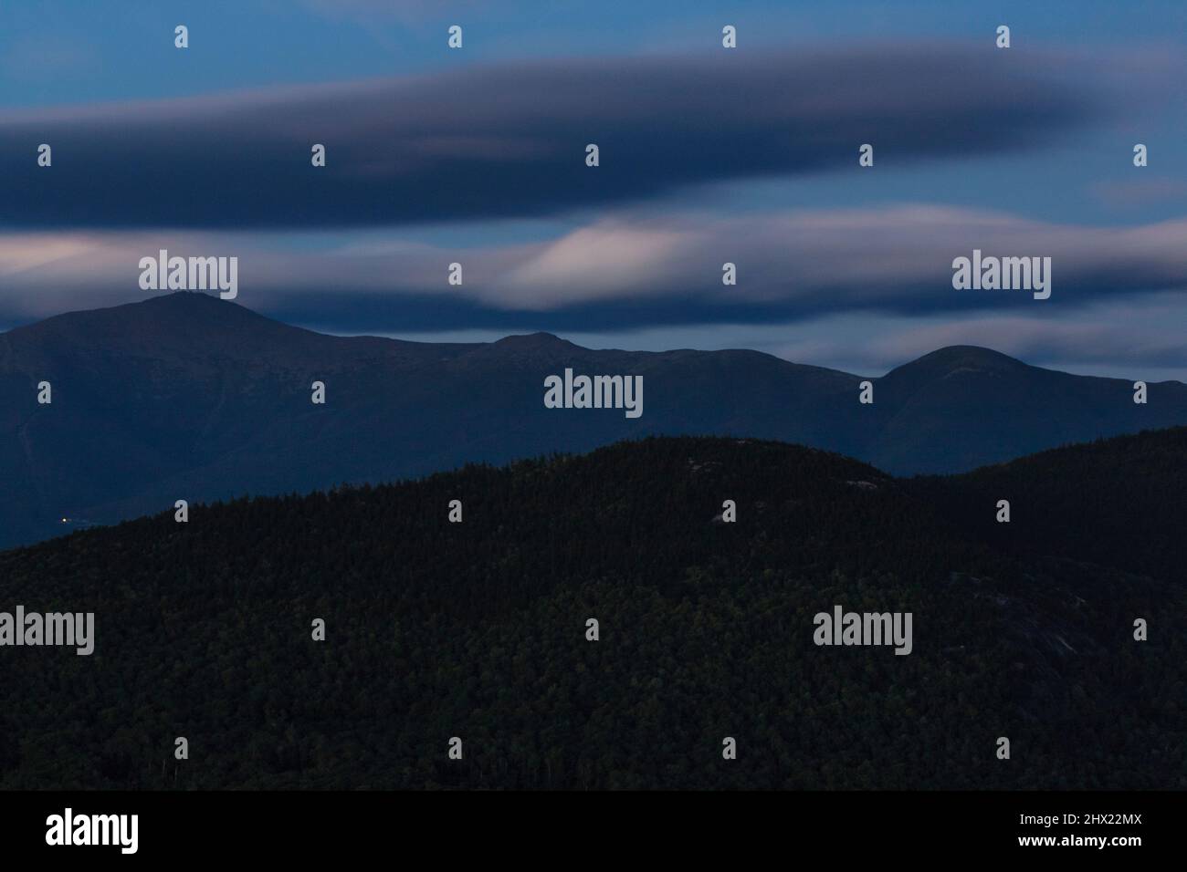 Silhouette of the Presidential Range from Middle Sugarloaf Mountain in Bethlehem, New Hampshire on a cloudy summer evening during twilight. Mount Wash Stock Photo