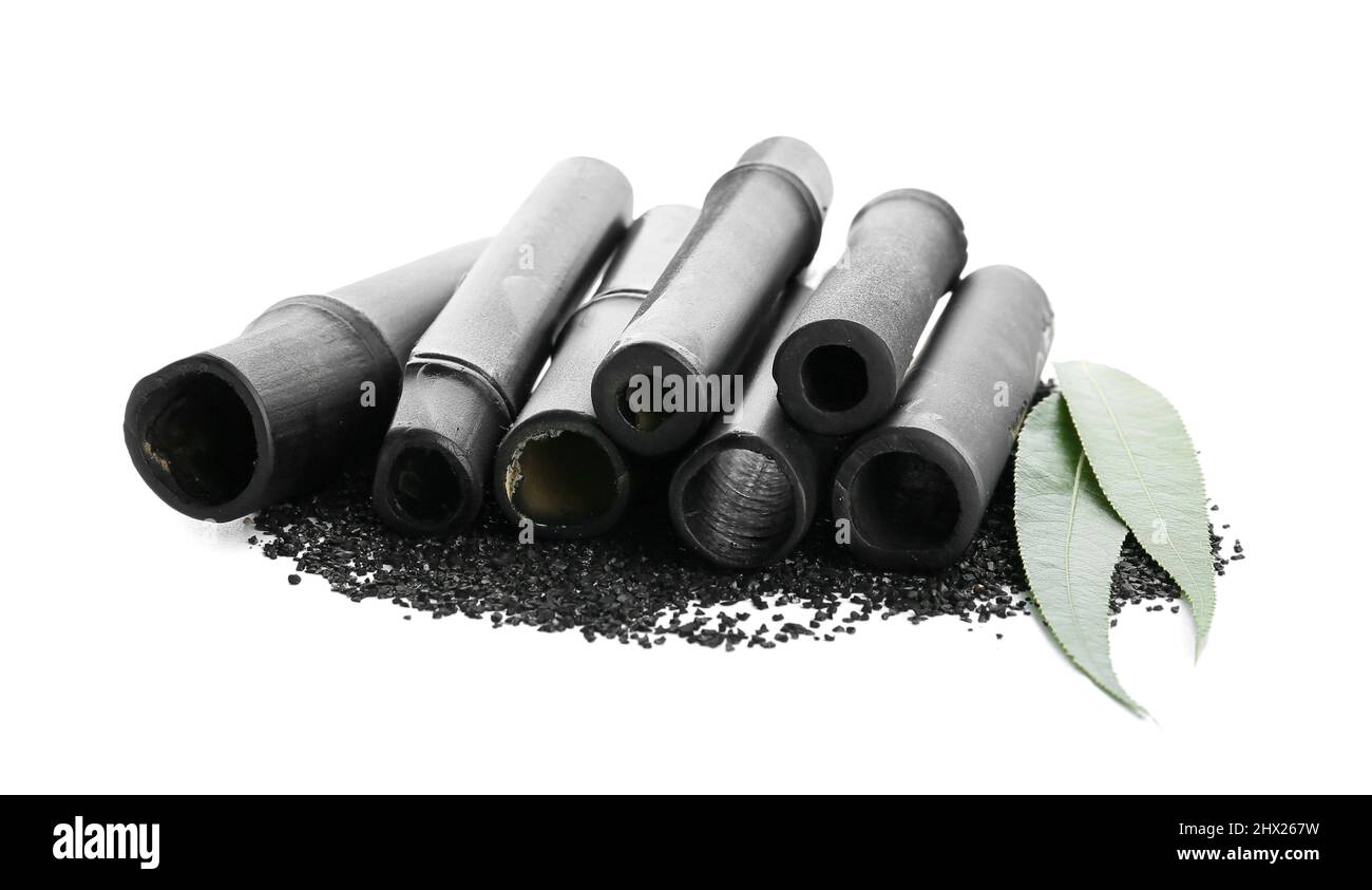 Black bamboo sticks and activated carbon powder on white background
