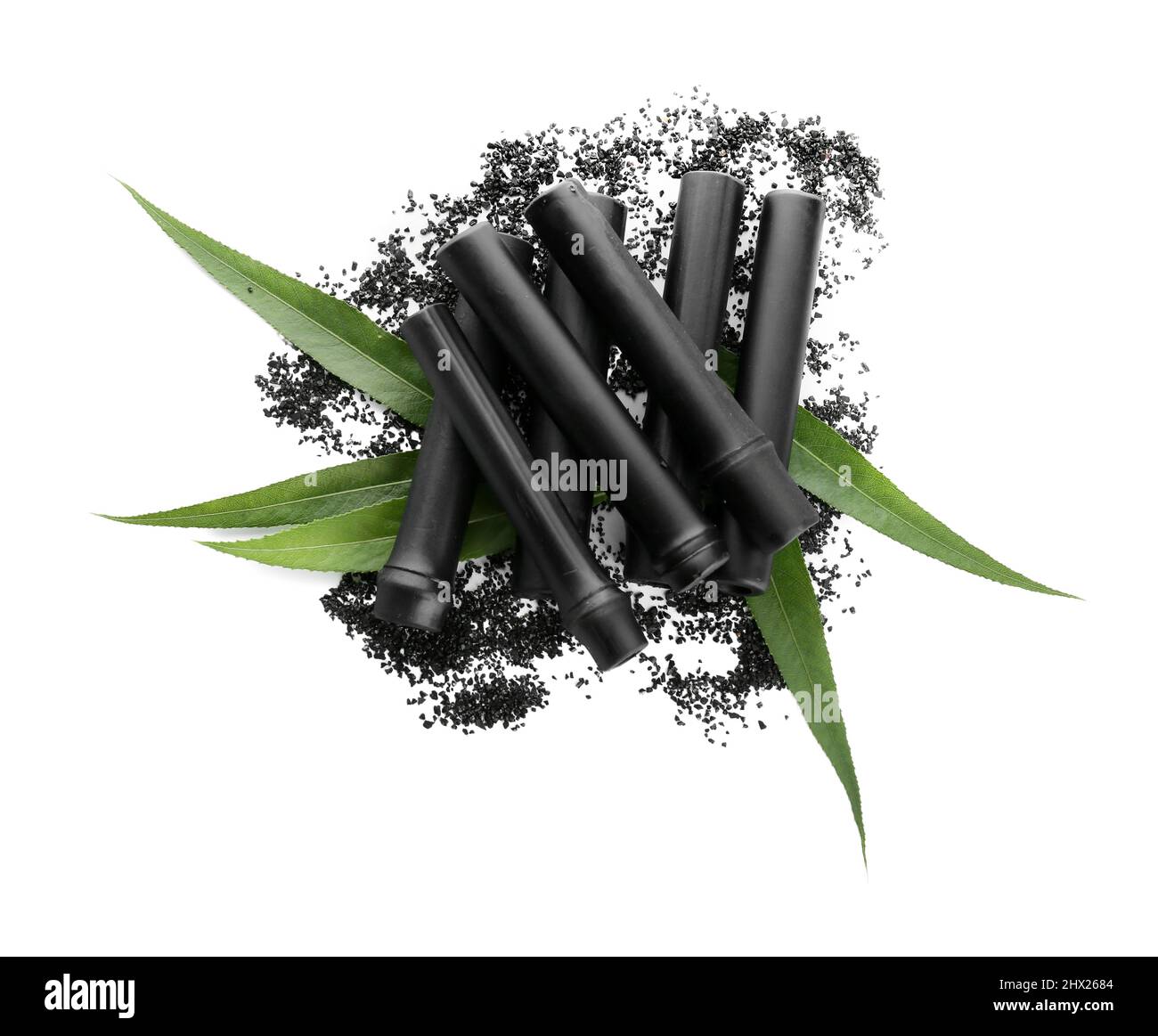 Black bamboo sticks and activated carbon powder isolated on white