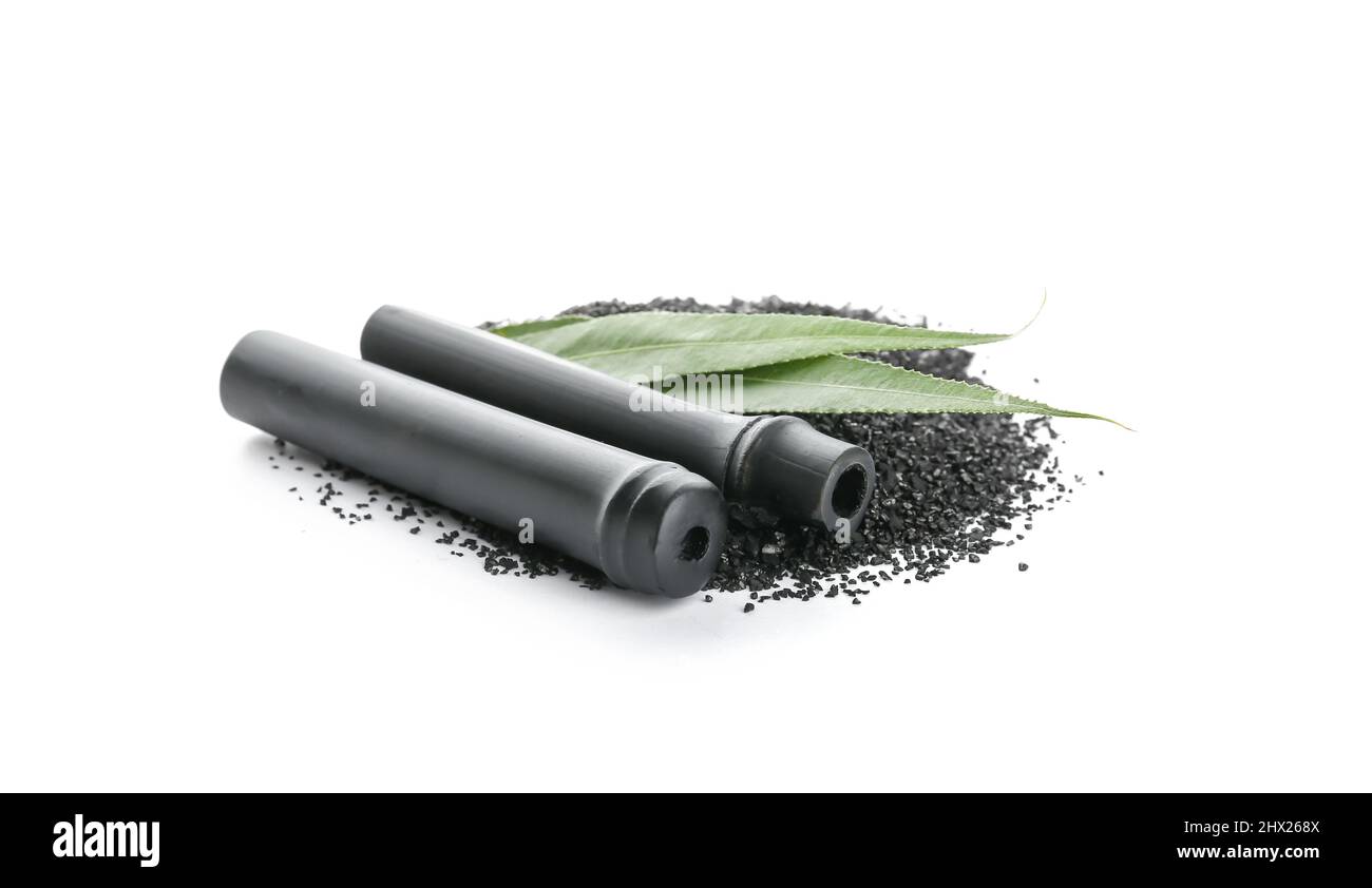 Black bamboo sticks and activated carbon powder isolated on white