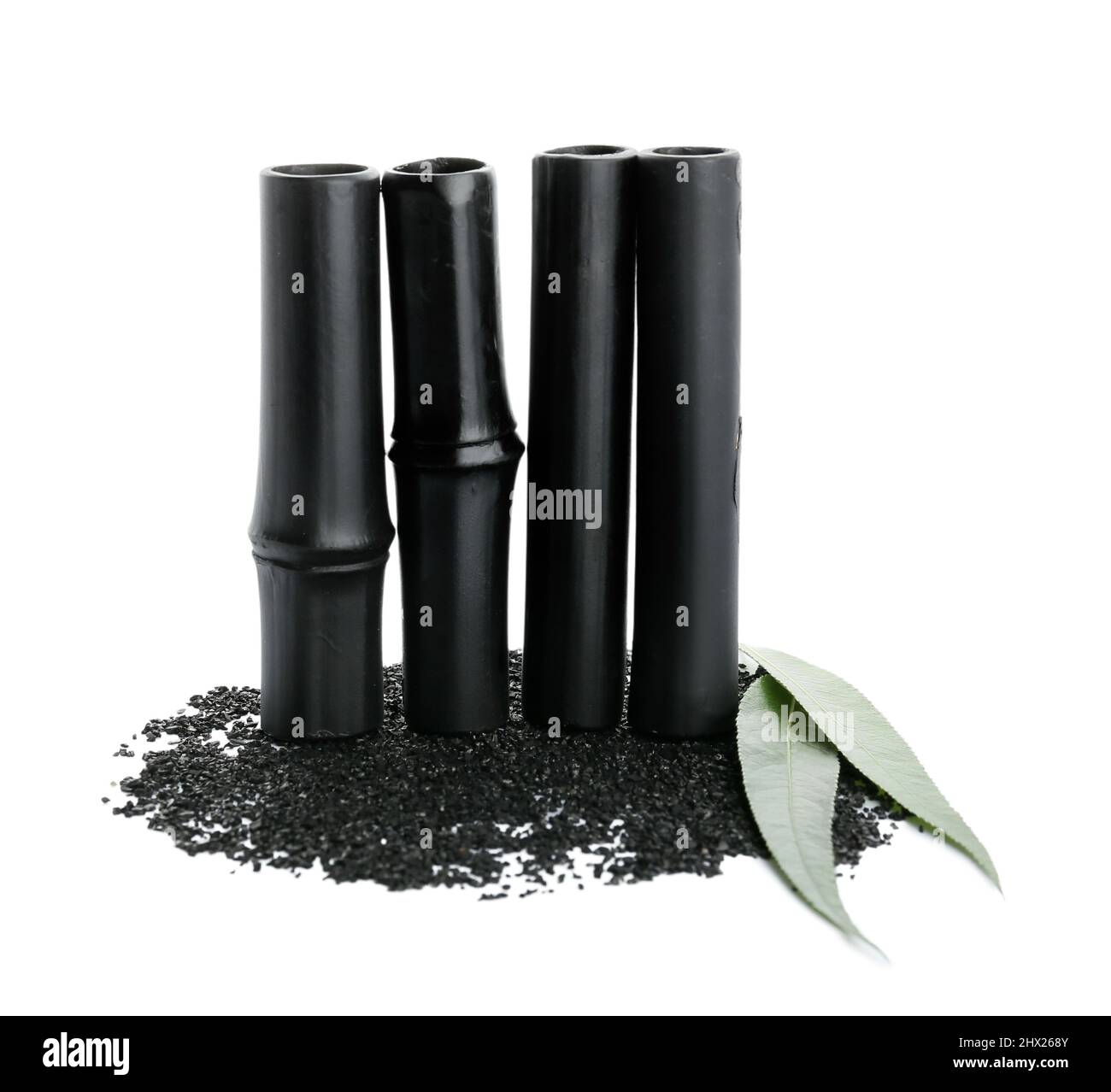 Black bamboo sticks and activated carbon powder on white background