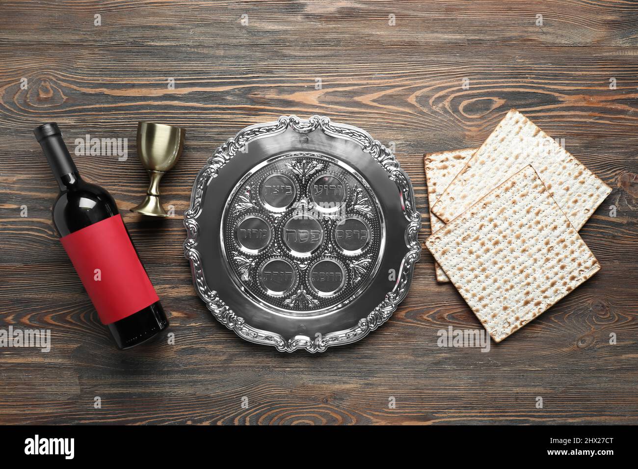 Passover Seder plate, flatbread matza and wine on wooden background ...