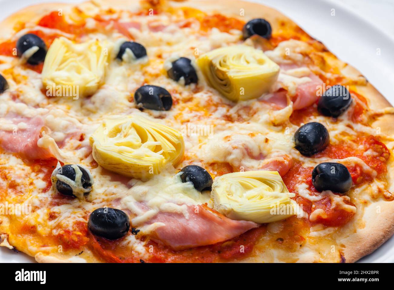 pizza with ham, black olives and artichokes Stock Photo Alamy