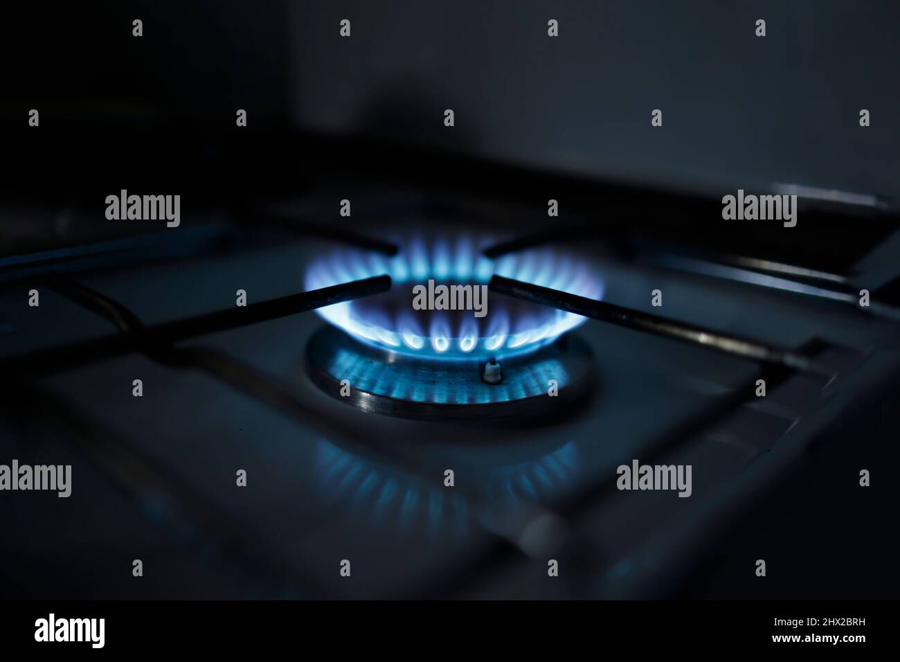 Gas stove burning in the dark during energy shortages Stock Photo