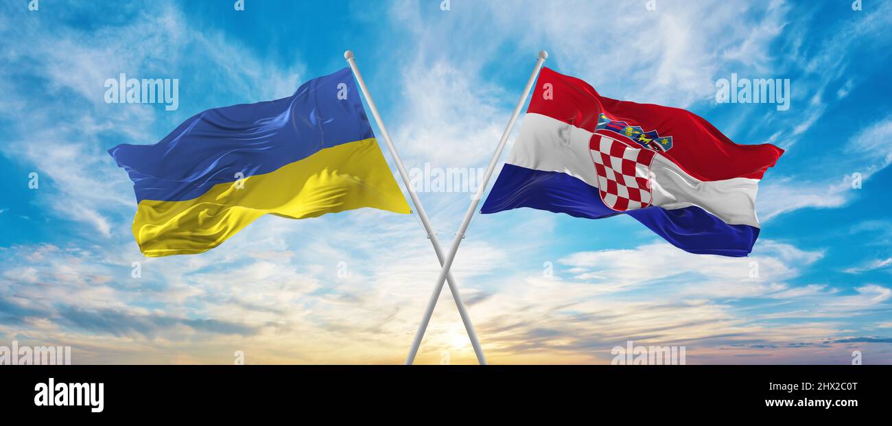 crossed national flags of Ukraine and Croatia flag waving in wind at cloudy sky. Symbolizing relationship, dialog, travelling between two countries. C Stock Photo