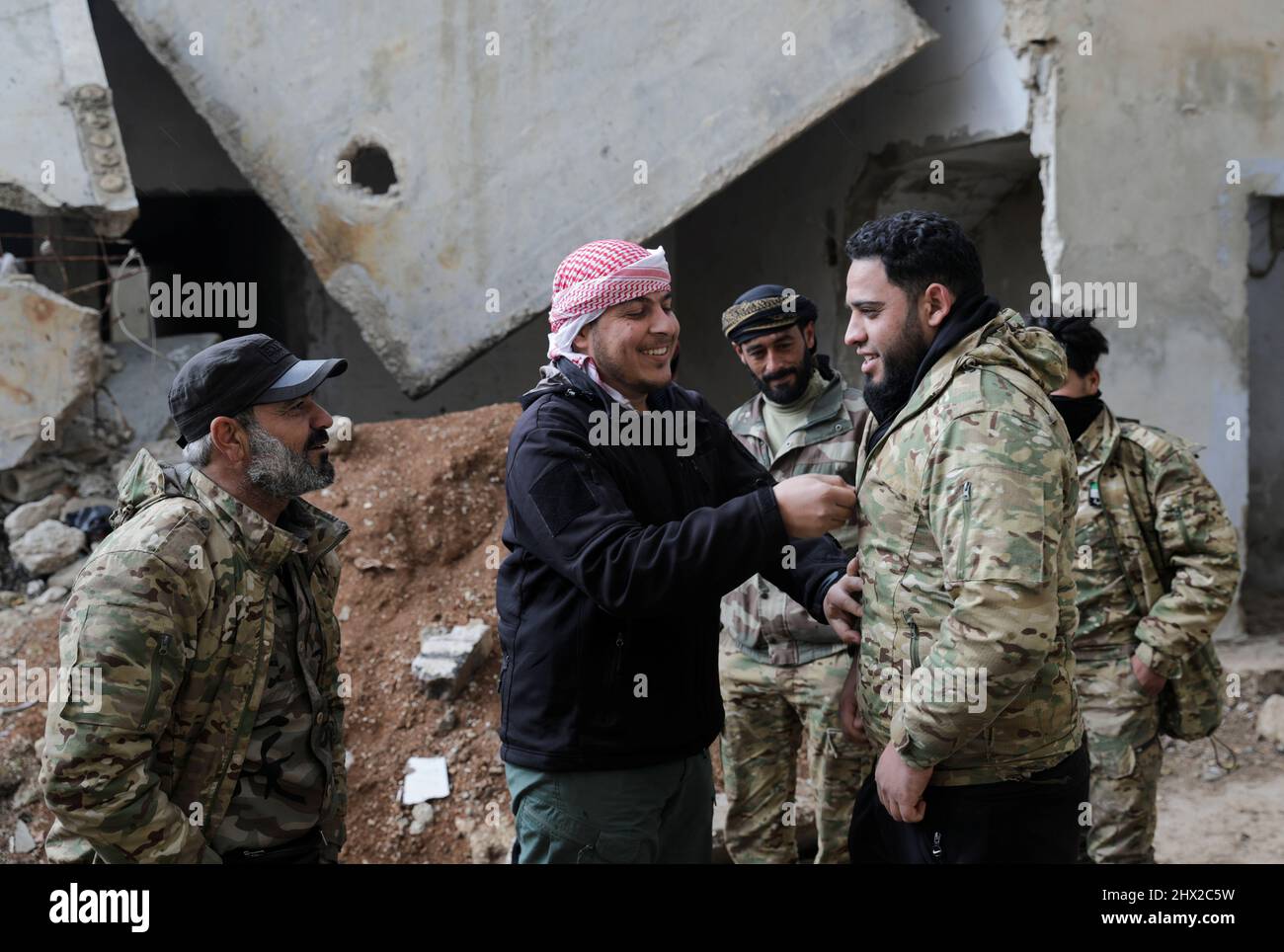 Syrian rebel fighter Abu Ahmad, chats with his comrades in the town of Tadef, on a frontline between Russian-backed Syrian government forces and Turkey-backed Syrian rebel-held territory, in northern Syria March 3, 2022. Picture taken March 3, 2022. REUTERS/Khalil Ashawi Stock Photo