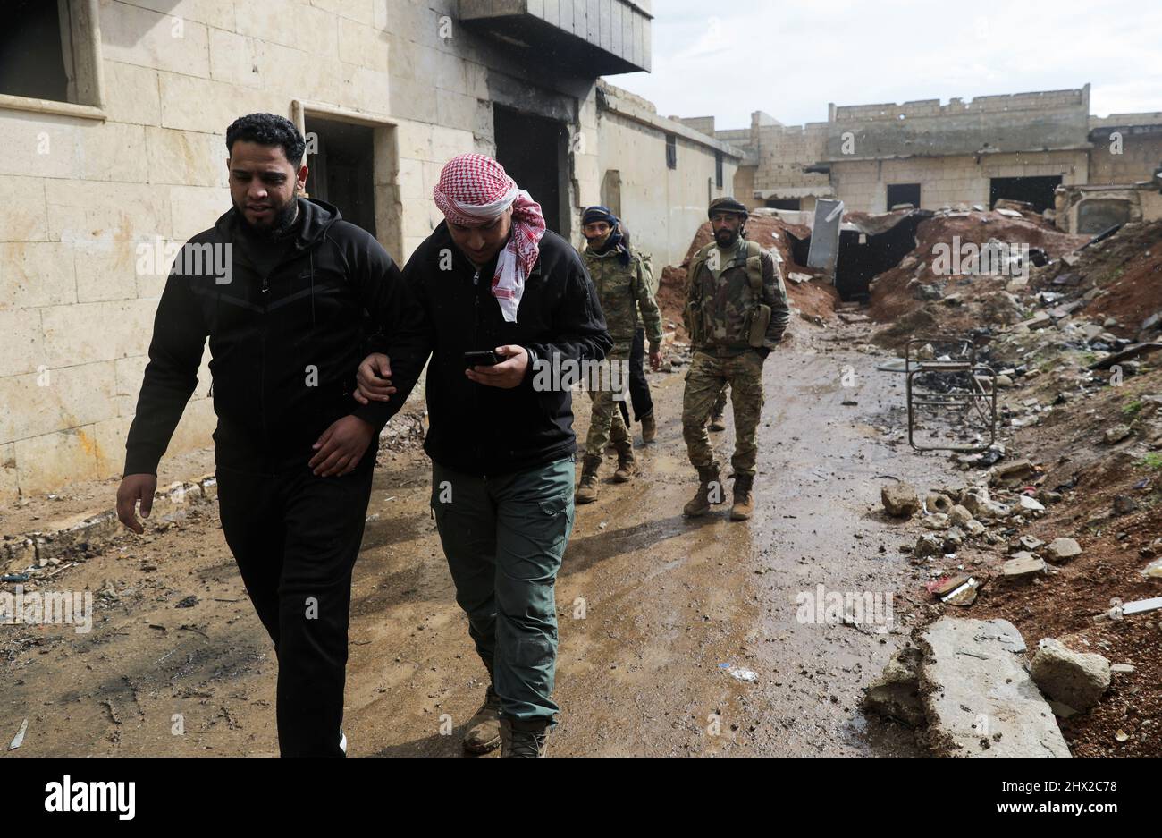 Syrian rebel fighter Abu Ahmad, walks with his comrades in the town of Tadef, on a frontline between Russian-backed Syrian government forces and Turkey-backed Syrian rebel-held territory, in northern Syria March 3, 2022. Picture taken March 3, 2022.  REUTERS/Khalil Ashawi Stock Photo