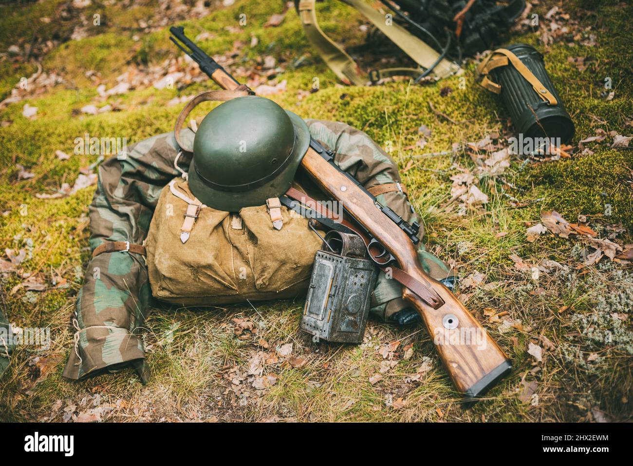German military ammunition of World War II on ground. Military helmet, lights, rifle Mauser Karabiner 98k. Stock Photo