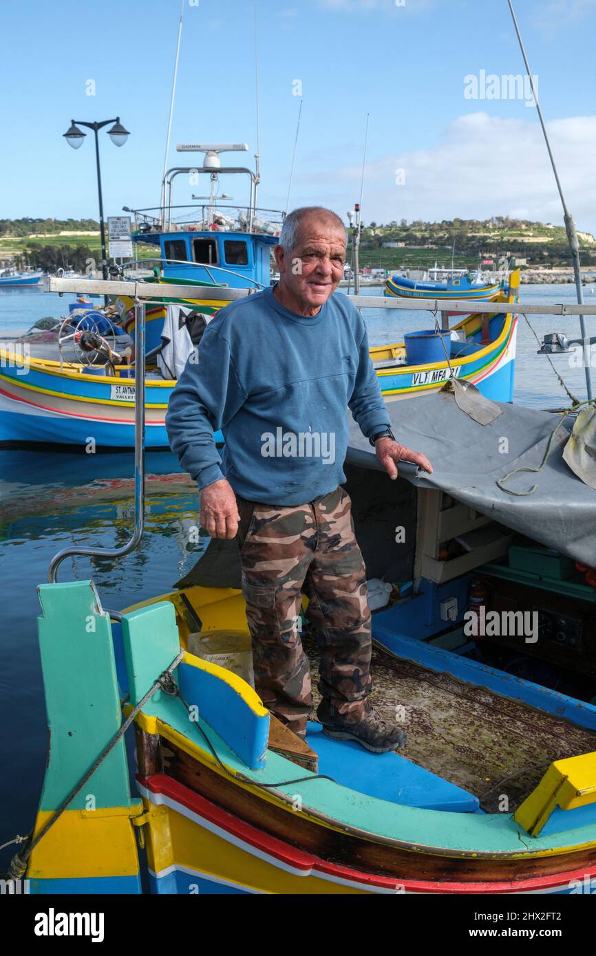 Fisherman on a luzzu, the traditional Maltese boat, Marsaxlokk, Malta Stock Photo