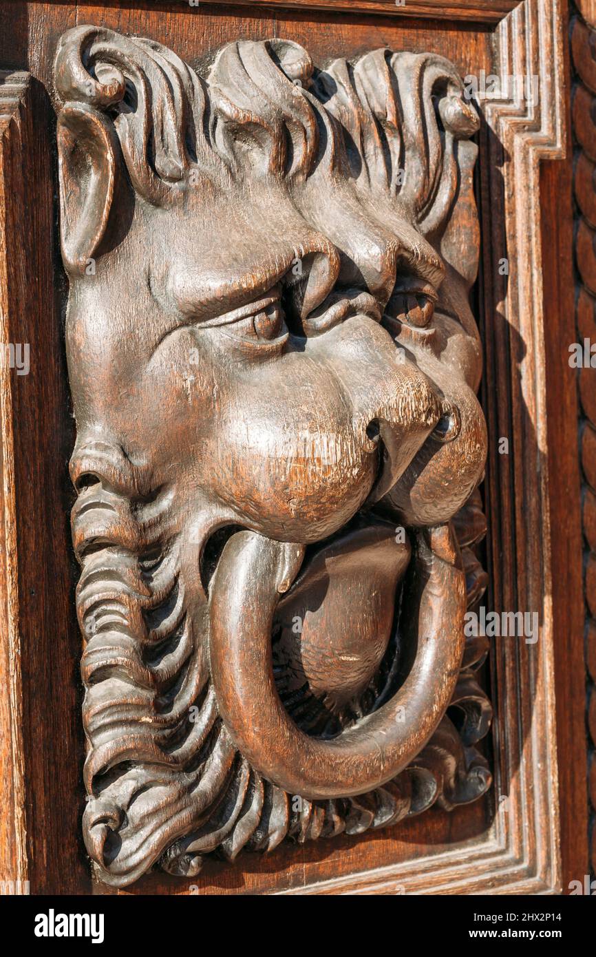 Lion head wood carving on old wooden door. Decorate detail Stock Photo