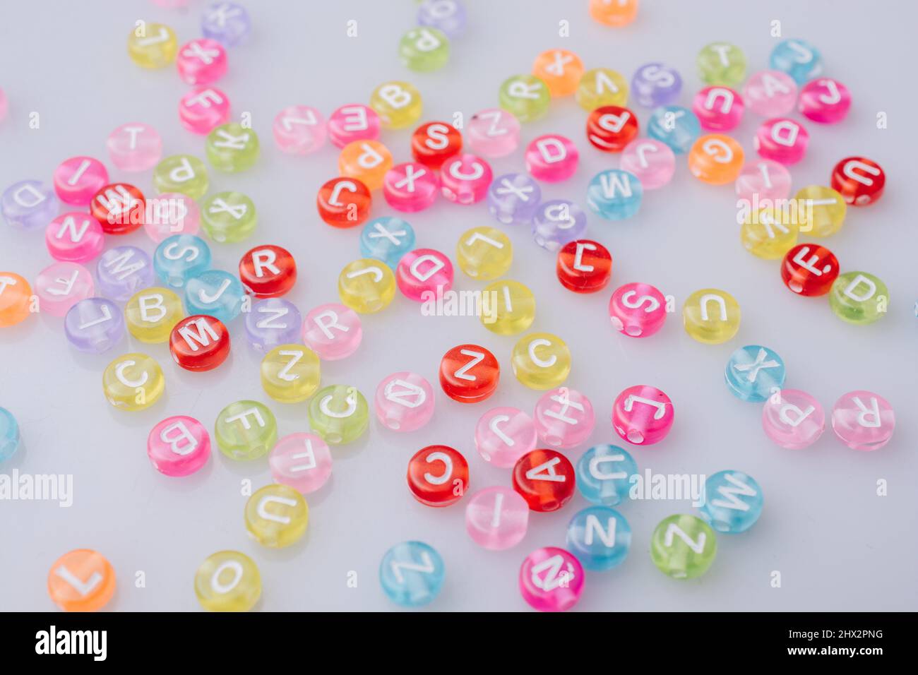 Multi color alphabet letter beads scattered randomly Stock Photo Alamy