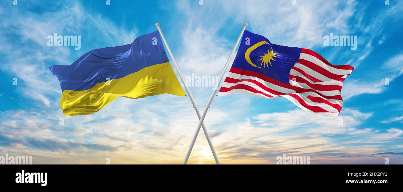 crossed national flags of Ukraine and Malaysia flag waving in wind at ...