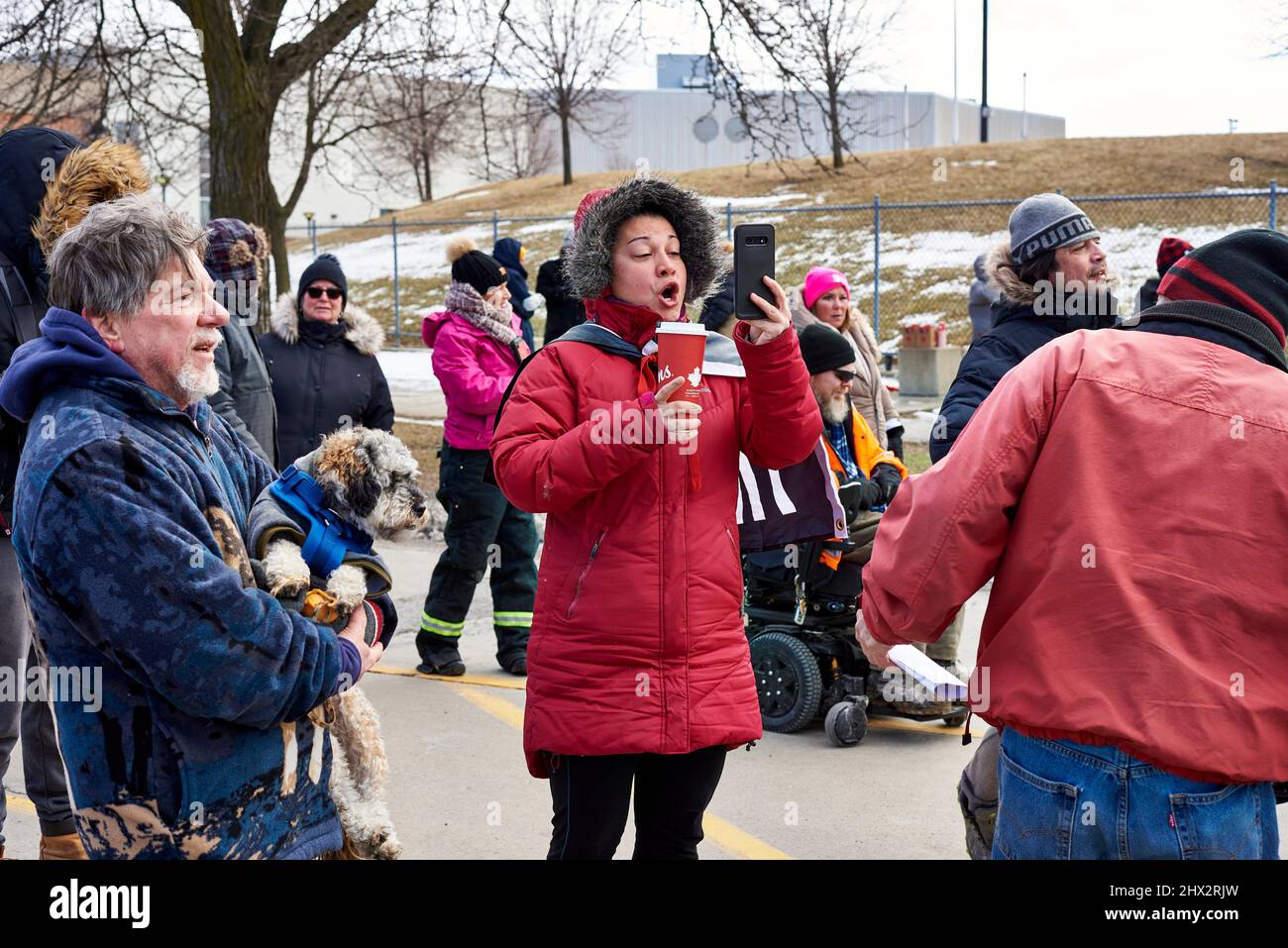 A woman protester makes a live feed on social media at a police barrier on 12 February 2022 near the Freddom Convoy blockade of the Ambassador Bridge Stock Photo