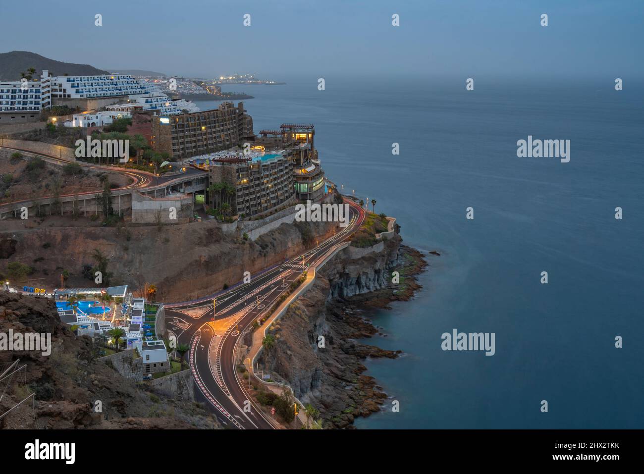 View of coastal road and hotels near Puerto Rico at dusk, Playa de Puerto Rico, Gran Canaria, Canary Islands, Spain, Europe Stock Photo