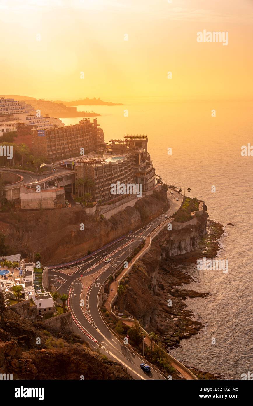 View of coastal road and hotels near Puerto Rico at sunsrise, Playa de Puerto Rico, Gran Canaria, Canary Islands, Spain, Europe Stock Photo